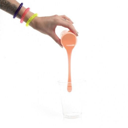 Hand holding a peach-colored bottle with a pump on a white background
