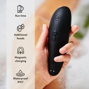 Black Womanizer Classic 2 Massager held in a hand with features listed on the left.